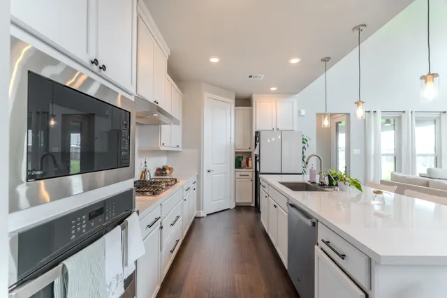 a large white kitchen with stainless steel appliances