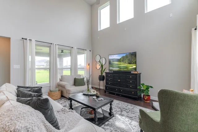 a living room with furniture wooden floor and a large window