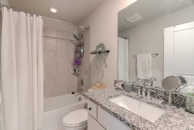 a bedroom with a bed a chandelier and a window