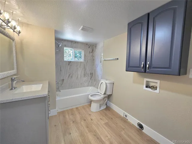a bathroom with a granite countertop toilet a sink and bathtub