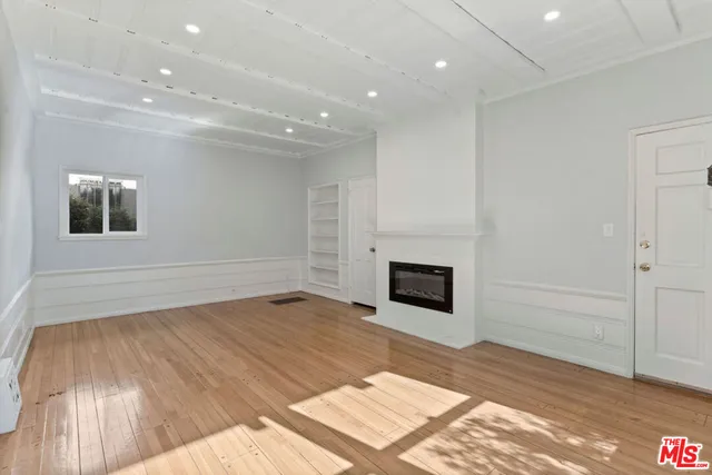 a view of empty room with wooden floor and fireplace