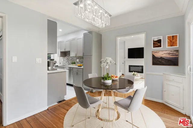 a dining room with furniture a chandelier and wooden floor