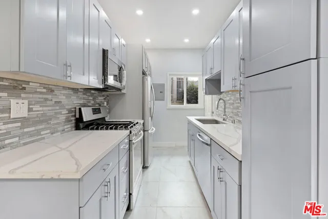 a kitchen with a sink a stove and cabinets
