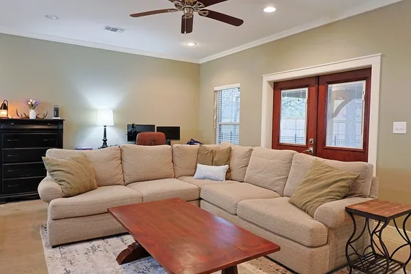 a living room with furniture ceiling fan and a window