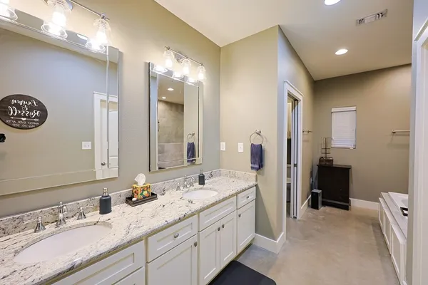 a spacious bathroom with a granite countertop sink and a mirror