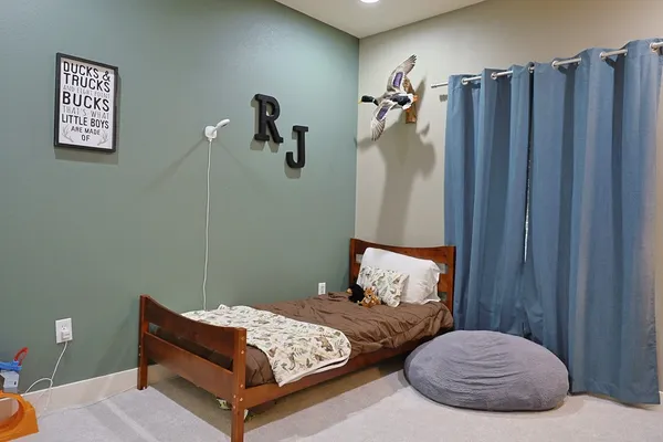 a bedroom with bed and wooden floor