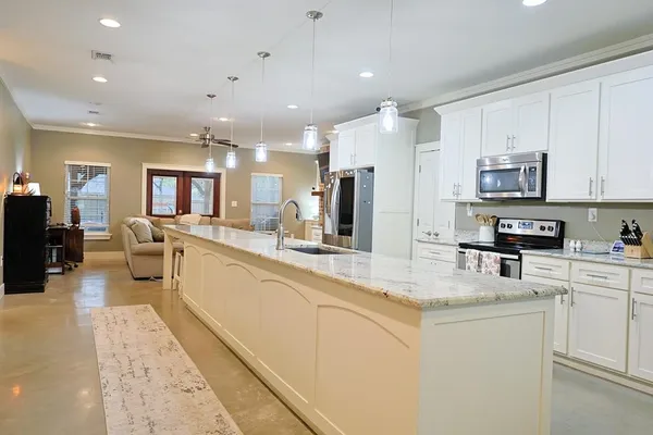 a large white kitchen with stainless steel appliances lots of counter top space