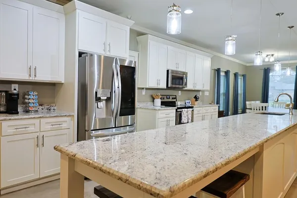a kitchen with stainless steel appliances granite countertop a sink a stove and a refrigerator