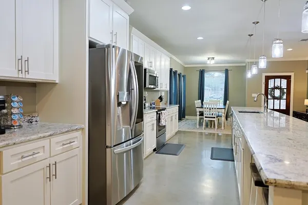 a kitchen with stainless steel appliances granite countertop a refrigerator and a sink