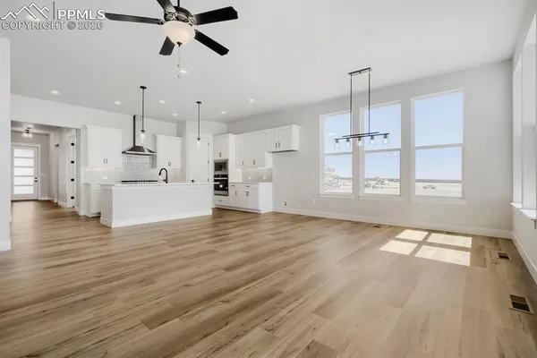 a view of empty room with wooden floor and window