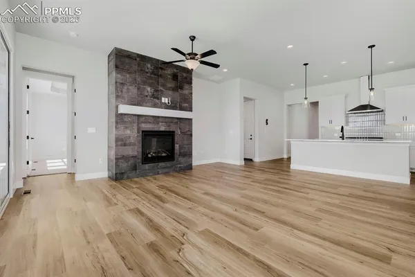a view of a room wooden floor and kitchen view