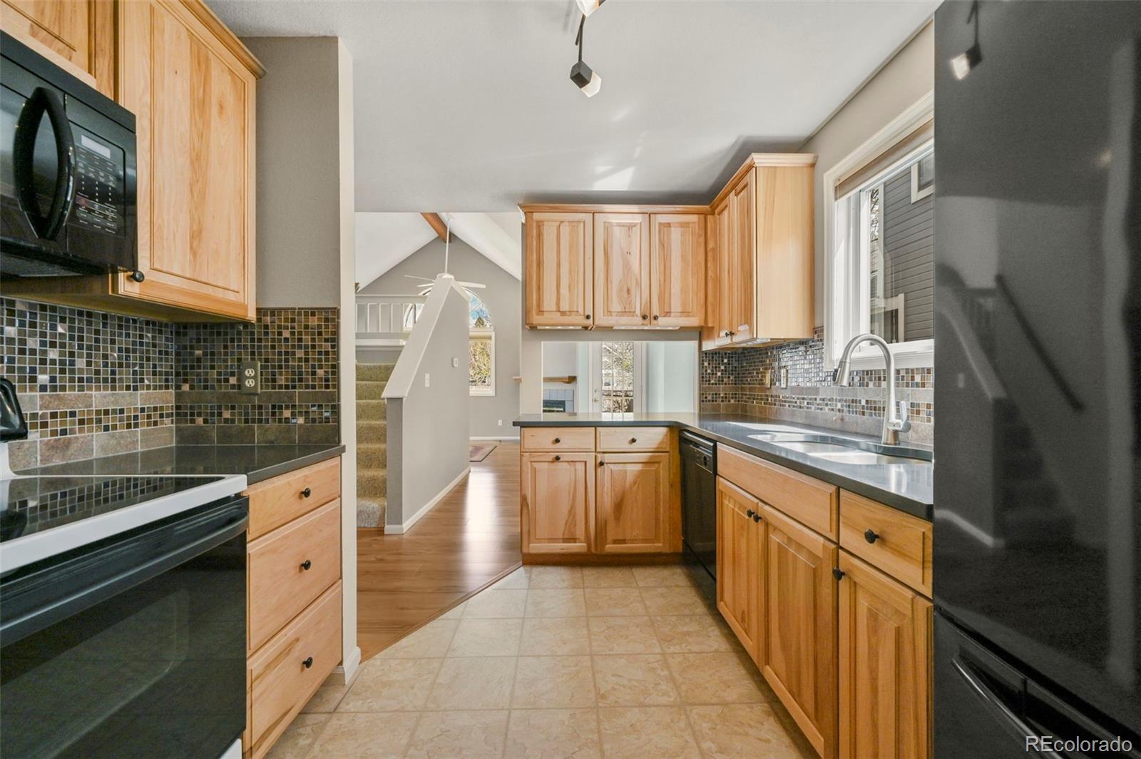 4829 Baldwin Place Boulder, CO 80301 - Photo 19 of 45 a kitchen with stainless steel appliances granite countertop a sink and dishwasher a stove top oven with wooden floor