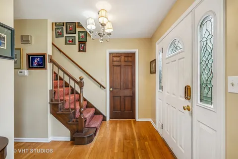 a view of a hallway with wooden floor and staircase