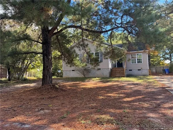a backyard of a house with large trees and a yard