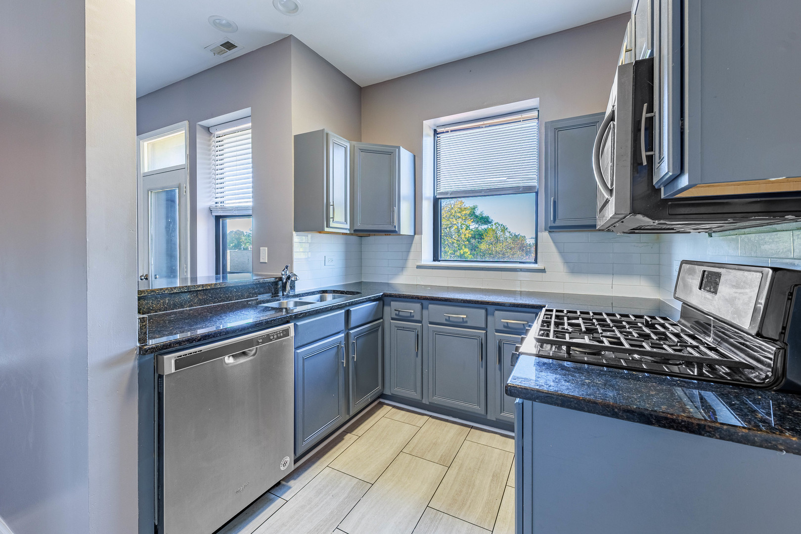 3704 South King Drive, Unit 3C Chicago, IL 60653 - Photo 11 of 26 a kitchen with stainless steel appliances granite countertop a sink stove and cabinets