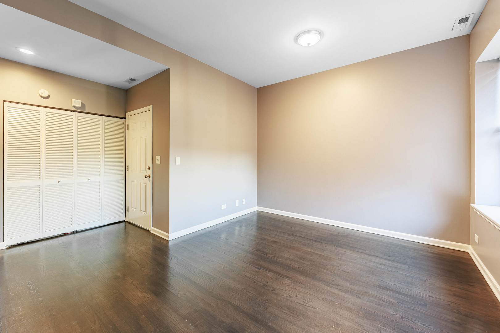 3704 South King Drive, Unit 3C Chicago, IL 60653 - Photo 6 of 26 an empty room with wooden floor and windows