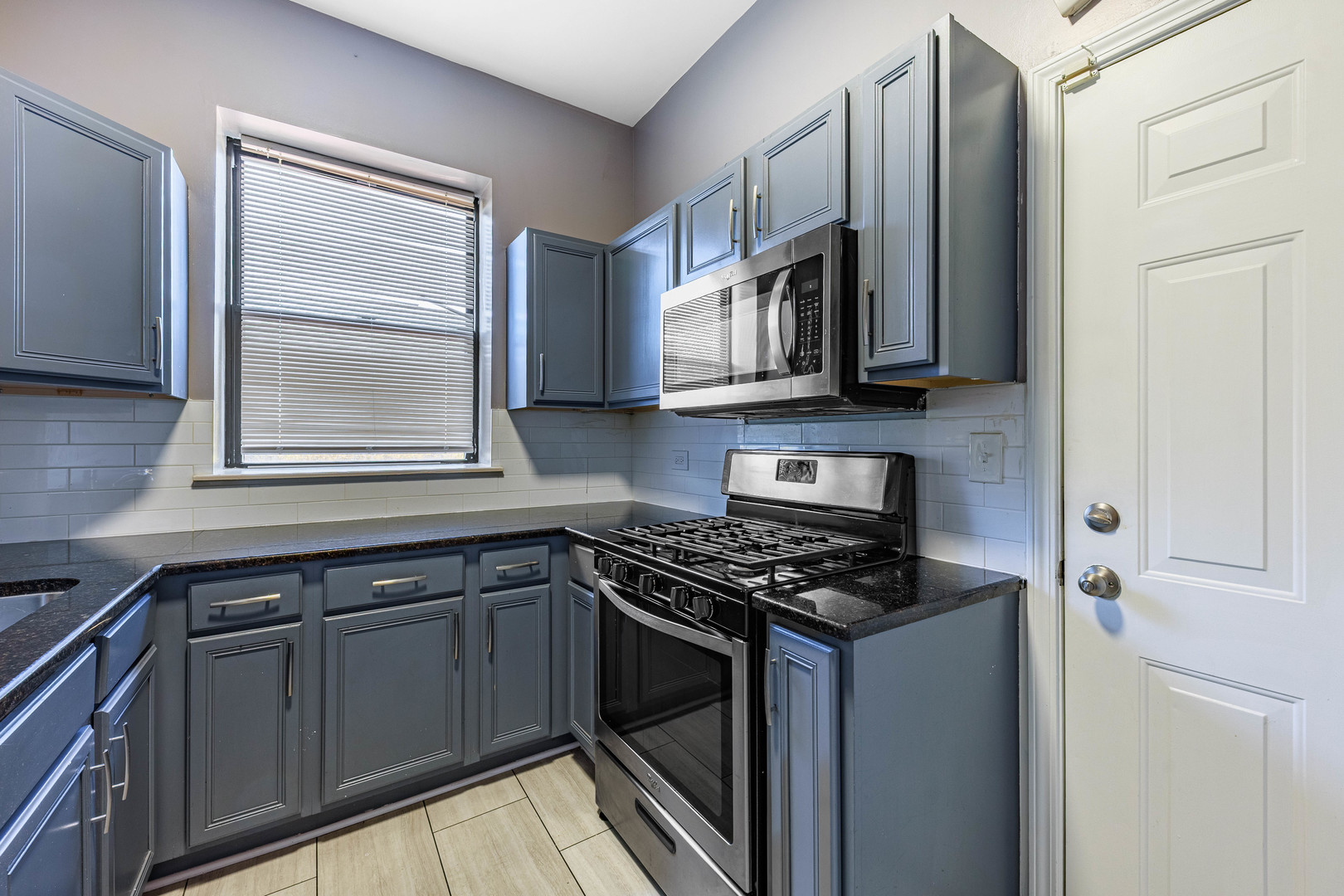 3704 South King Drive, Unit 3C Chicago, IL 60653 - Photo 8 of 26 a kitchen with stainless steel appliances granite countertop a stove a sink and a microwave