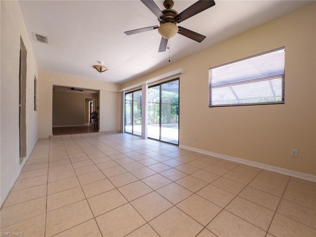 18414 Tulip Road Fort Myers, FL 33967 - Photo 17 of 37 Spacious interior room featuring light-toned tile flooring, direct access to a patio area through sliding glass doors, a ceiling fan with integrated lighting, and a recessed window with horizontal blinds