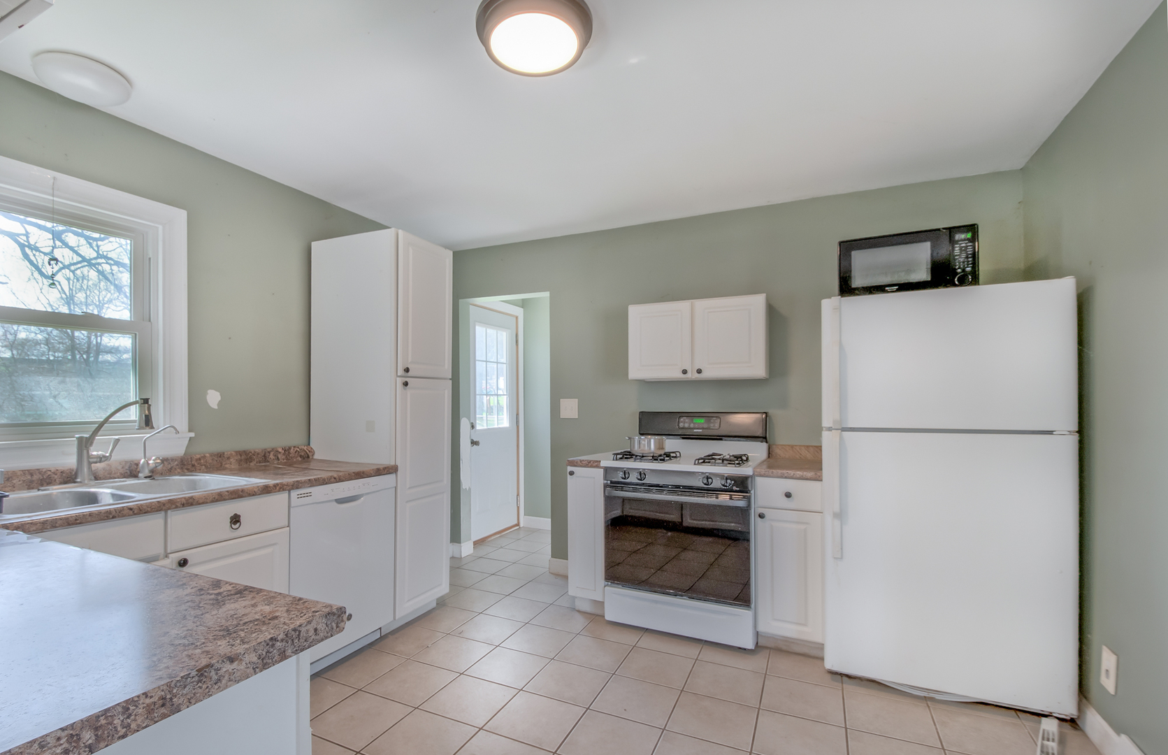 4113 West Crystal Lake Road McHenry, IL 60050 - Photo 7 of 14 a kitchen with stainless steel appliances a stove a sink and a refrigerator
