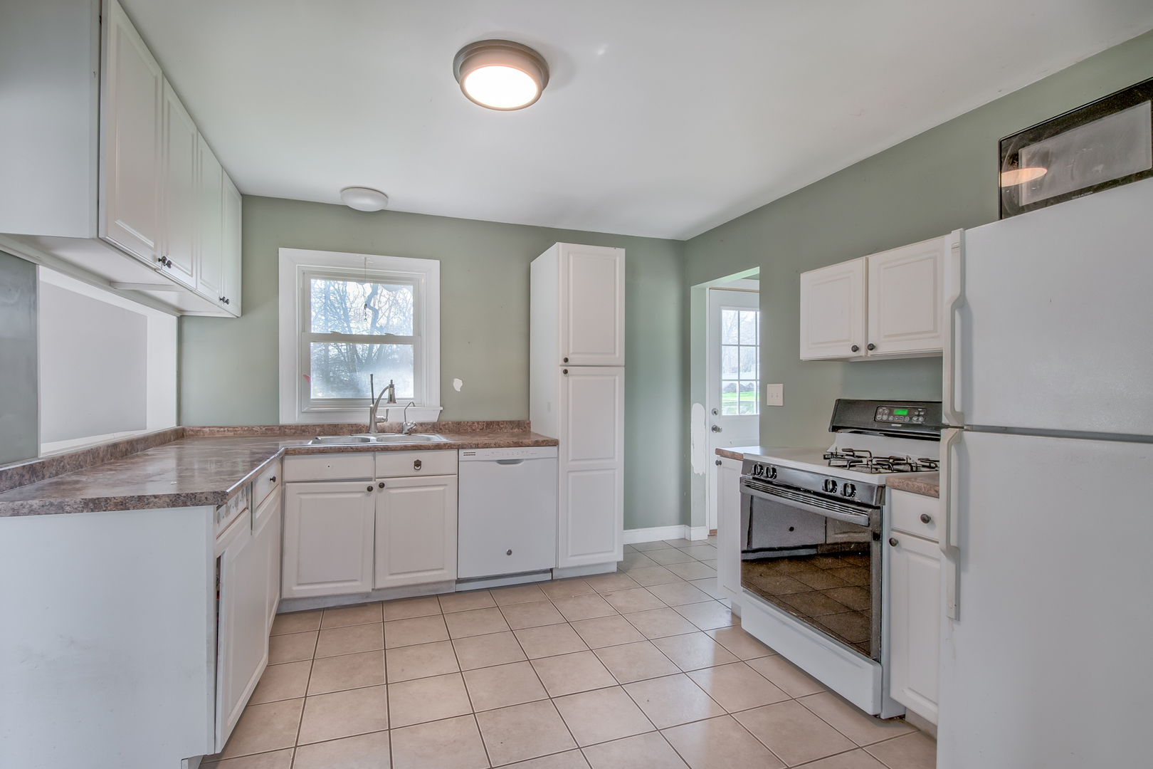 4113 West Crystal Lake Road McHenry, IL 60050 - Photo 8 of 14 a kitchen with white cabinets and appliances