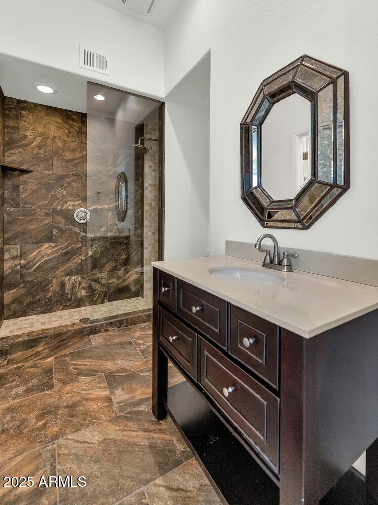7878 East Gainey Ranch Road, Unit 25 Scottsdale, AZ 85258 - Photo 28 of 42 a bathroom with a sink a mirror and a shower
