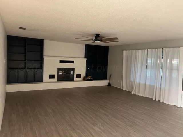 an empty room with a fireplace and cabinet