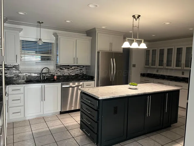 a kitchen with stainless steel appliances granite countertop a sink a stove a refrigerator and cabinets