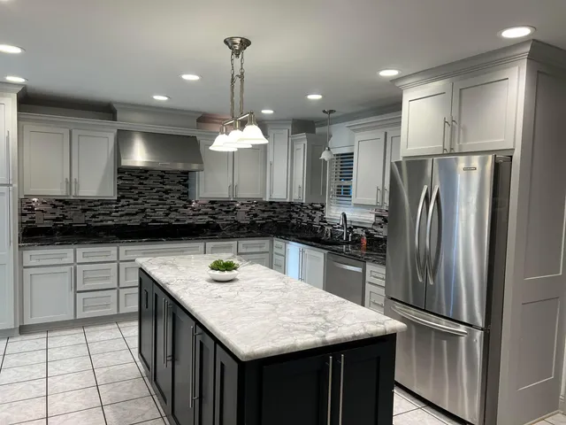 a kitchen with kitchen island a sink stainless steel appliances and cabinets