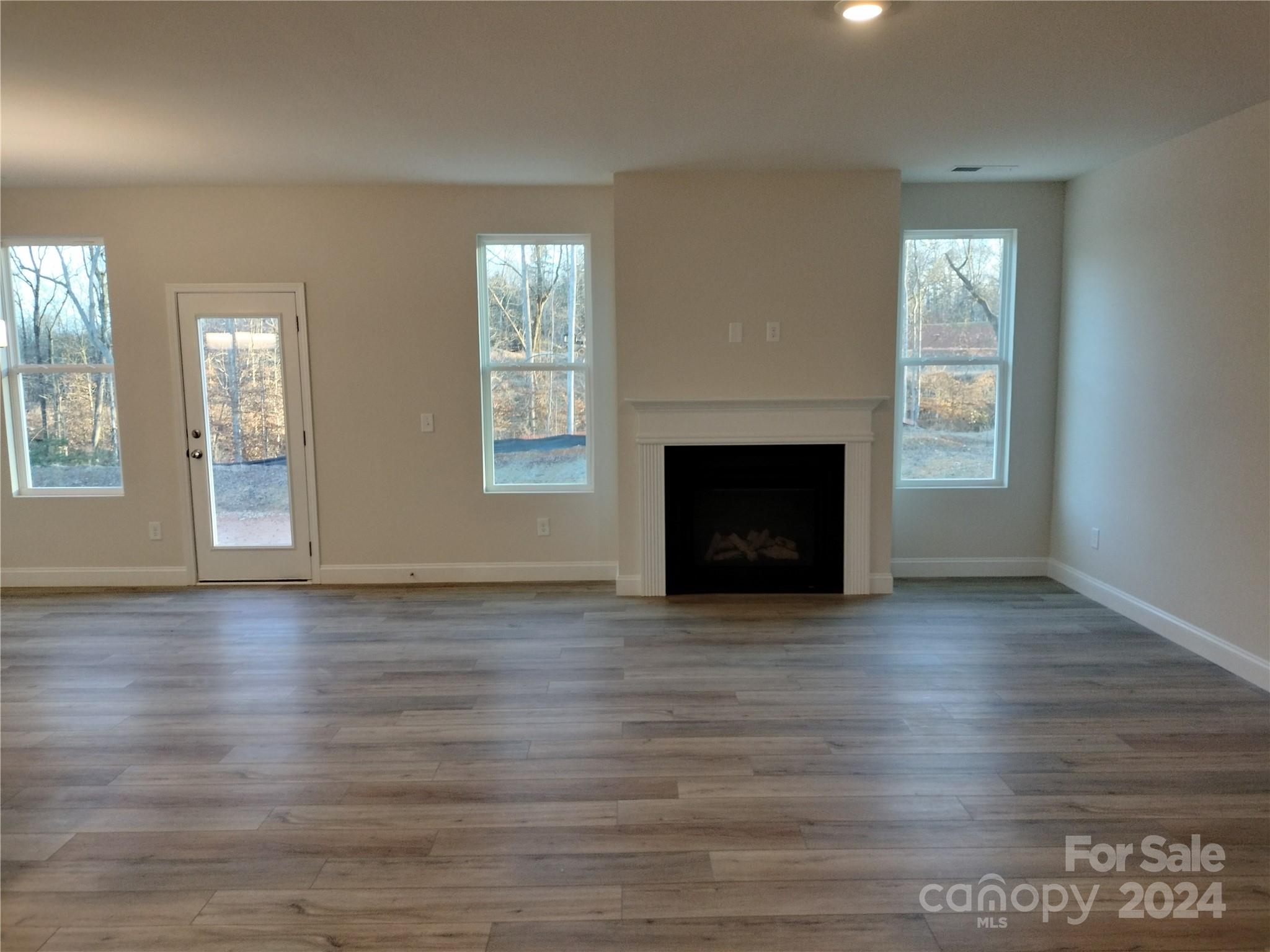 252 Hamrick Road, Unit 10 Cramerton, NC 28056 - Photo 11 of 37 an empty room with wooden floor fireplace and windows