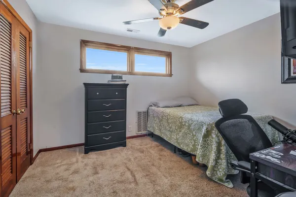 a bedroom with a bed a chandelier and a window