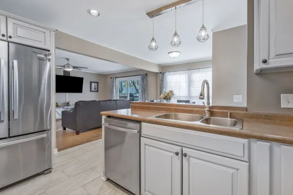 a kitchen with stainless steel appliances granite countertop a sink and a refrigerator