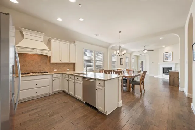 a kitchen with white cabinets and sink
