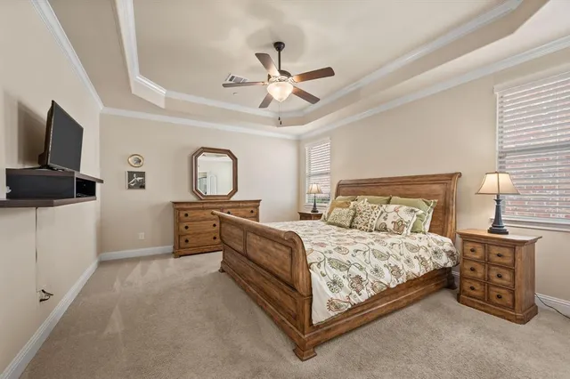 a bedroom with a bed and a flat tv screen on dresser