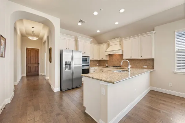 a kitchen with stainless steel appliances granite countertop a refrigerator sink and cabinets