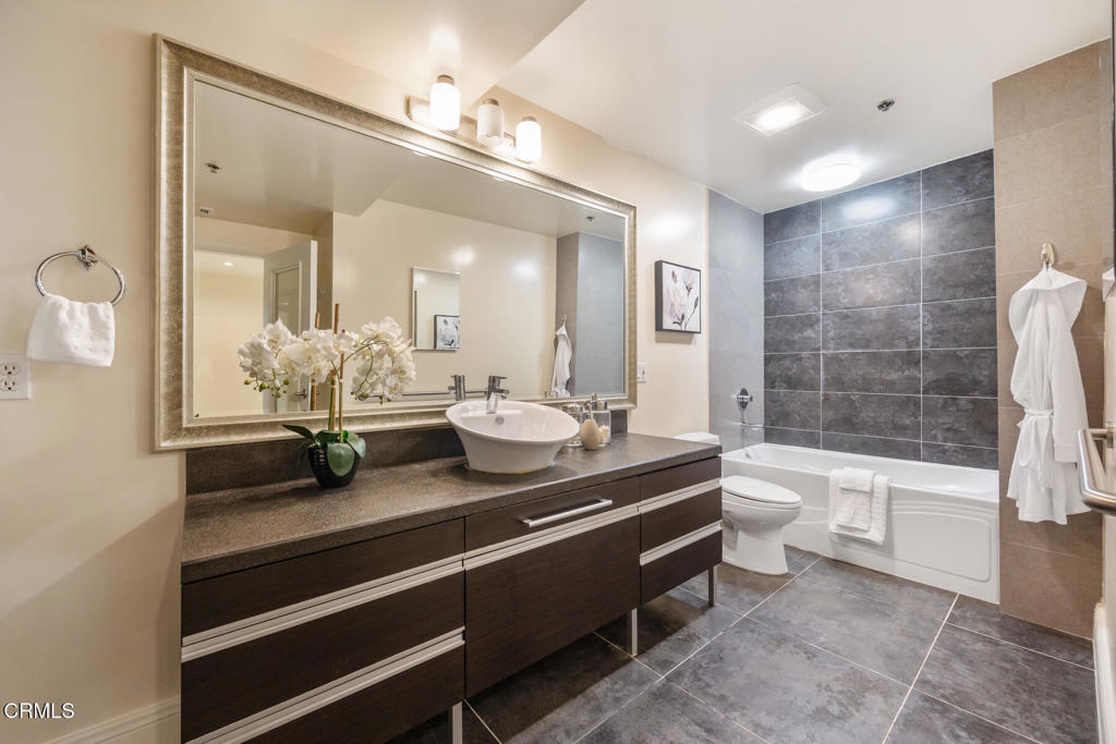 120 South Mentor Avenue, Unit 202 Pasadena, CA 91106 - Photo 23 of 40 a spacious bathroom with a granite countertop sink mirror toilet and bathtub