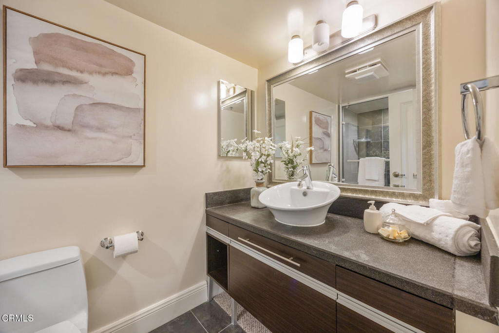 120 South Mentor Avenue, Unit 202 Pasadena, CA 91106 - Photo 26 of 40 a bathroom with a granite countertop sink a toilet and a mirror