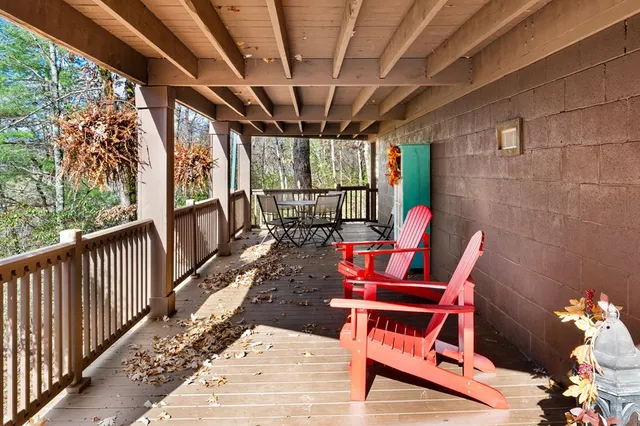 a view of a house with a wooden fence and a large tree