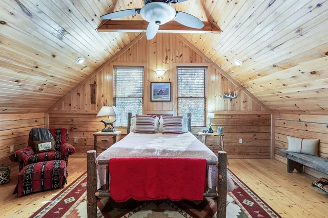 a bedroom with a bed and wooden floors