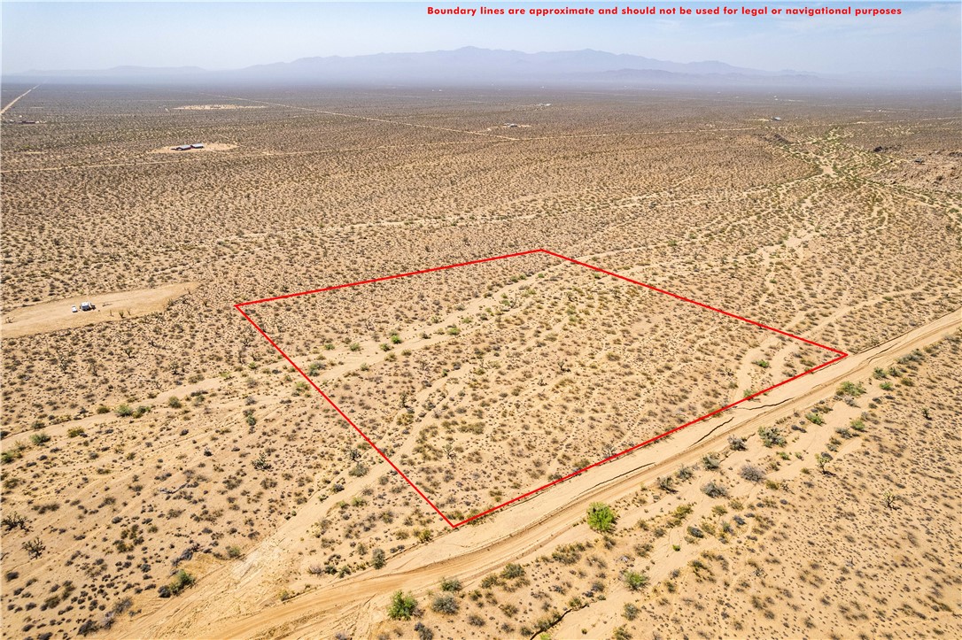 0 East Arroyo Road Yucca, AZ 86438 - Photo 1 of 25 Expansive desert land featuring a clear property boundary, a visible dirt road, and distant mountains