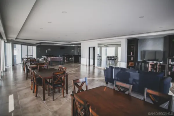 a kitchen with stainless steel appliances granite countertop a refrigerator a stove a sink a dining table and chairs