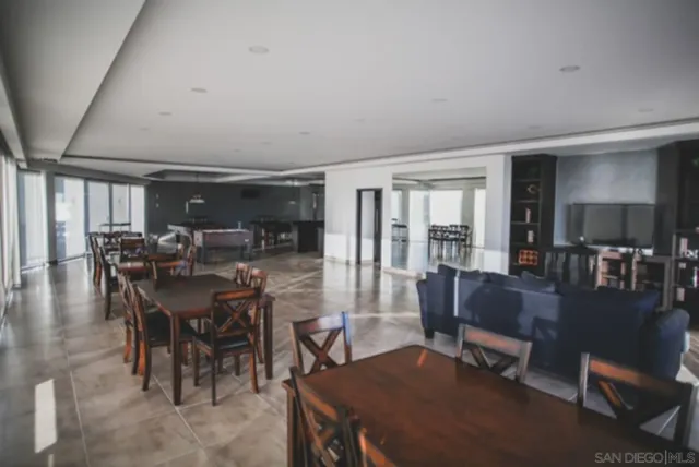 a kitchen with stainless steel appliances granite countertop a refrigerator a stove a sink a dining table and chairs