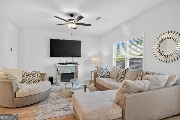 a living room with furniture a fireplace and a flat screen tv