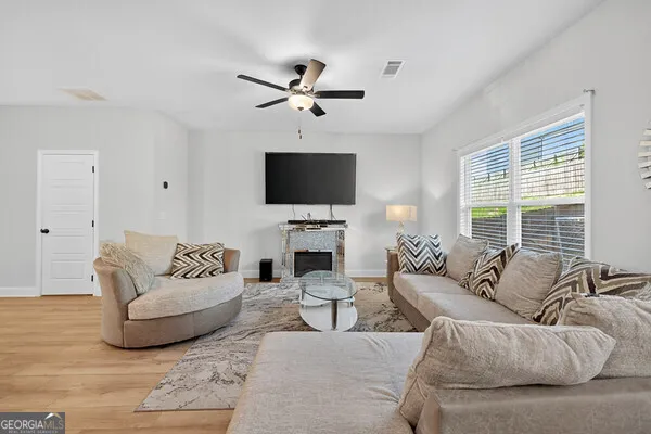 a living room with furniture a fireplace and a flat screen tv