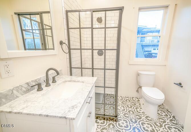 1416 Bath Street Santa Barbara, CA 93101 - Photo 5 of 15 a bathroom with a granite countertop sink toilet a mirror and next to a window