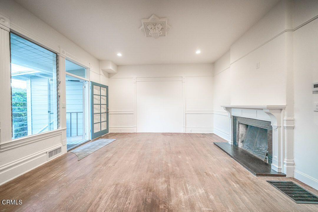 1416 Bath Street Santa Barbara, CA 93101 - Photo 8 of 15 a view of empty room with wooden floor and fireplace