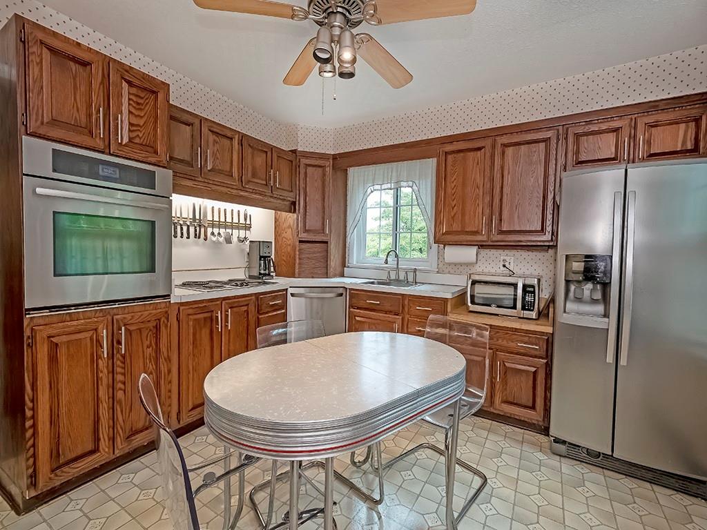 1587 Anderson Road Pittsburgh, PA 15209 - Photo 8 of 22 a kitchen with stainless steel appliances granite countertop a sink a stove a refrigerator cabinets and dining table