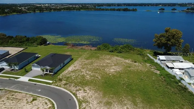 an aerial view of a house with a yard and lake view