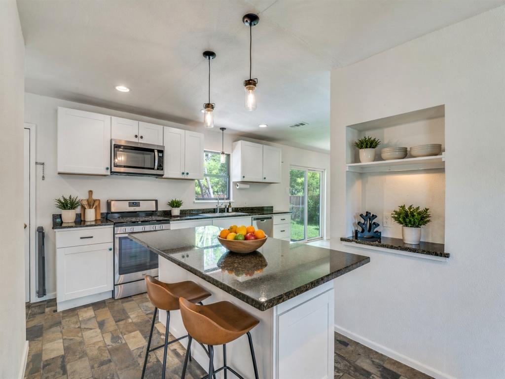 2315 Inadale Avenue Dallas, TX 75228 - Photo 12 of 36 a kitchen with a sink a stove and chairs
