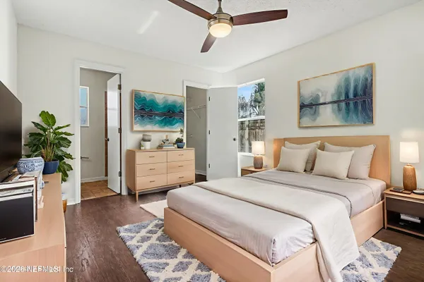 a bedroom with a bed dresser and a flat tv screen