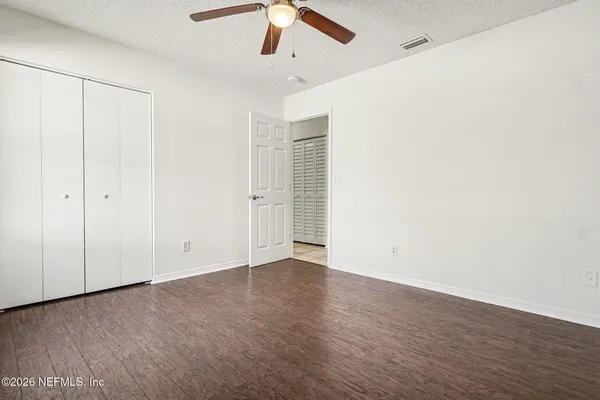 a view of an empty room with wooden floor